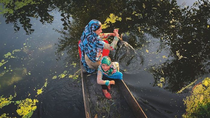A woman rows her shikara through the backwaters of Dal Lake. | Ashish Sharma