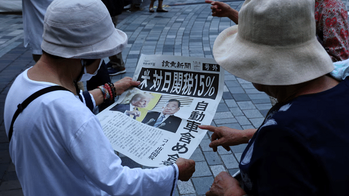 People react as they read a special edition of Yomiuri Shimbun newspaper reporting the tariff deal agreement between U.S and Japan, in Tokyo, Japan, July 23, 2025 | Reuters