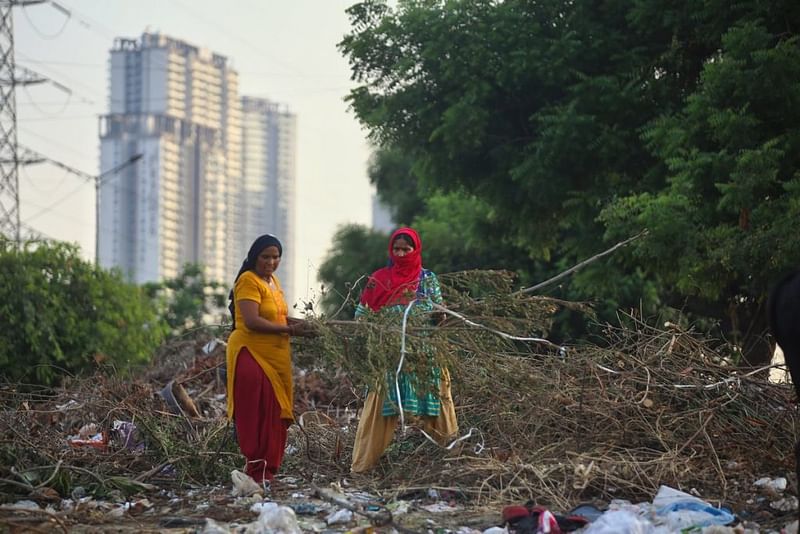 सूरज ढलते ही सुशांत लोक फेज-2 की मुख्य सड़क पर झुग्गी-बस्तियों के लोग कूड़े के ढेर पर पहुंचने लगते हैं | फोटो: मनीषा मोंडल/दिप्रिंट