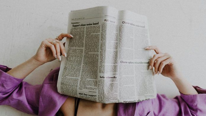 A woman with the newspaper on her face.