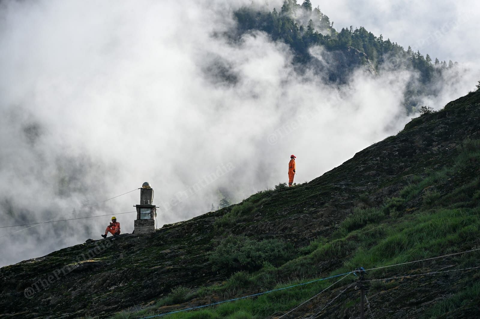NDRF personnel monitor the flow of water from a hilltop | Suraj Singh Bisht | ThePrint