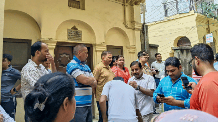 People gather outside the residence of AAP leader Saurabh Bharadwaj amid a raid being conducted against him and others by the Enforcement Directorate, 26 Aug | PTI