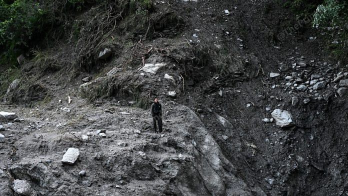 A man stares into the void along a road in Uttarkashi washed away by flash flood | Suraj Singh Bisht | ThePrint