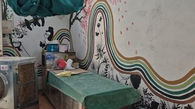 कांकेर के मुर्दाघर में पोस्टमार्टम टेबल, एक साधारण कूलर और चमकीले भित्तिचित्रों से घिरा हुआ | फोटो: शुभांगी मिश्रा/दिप्रिंट