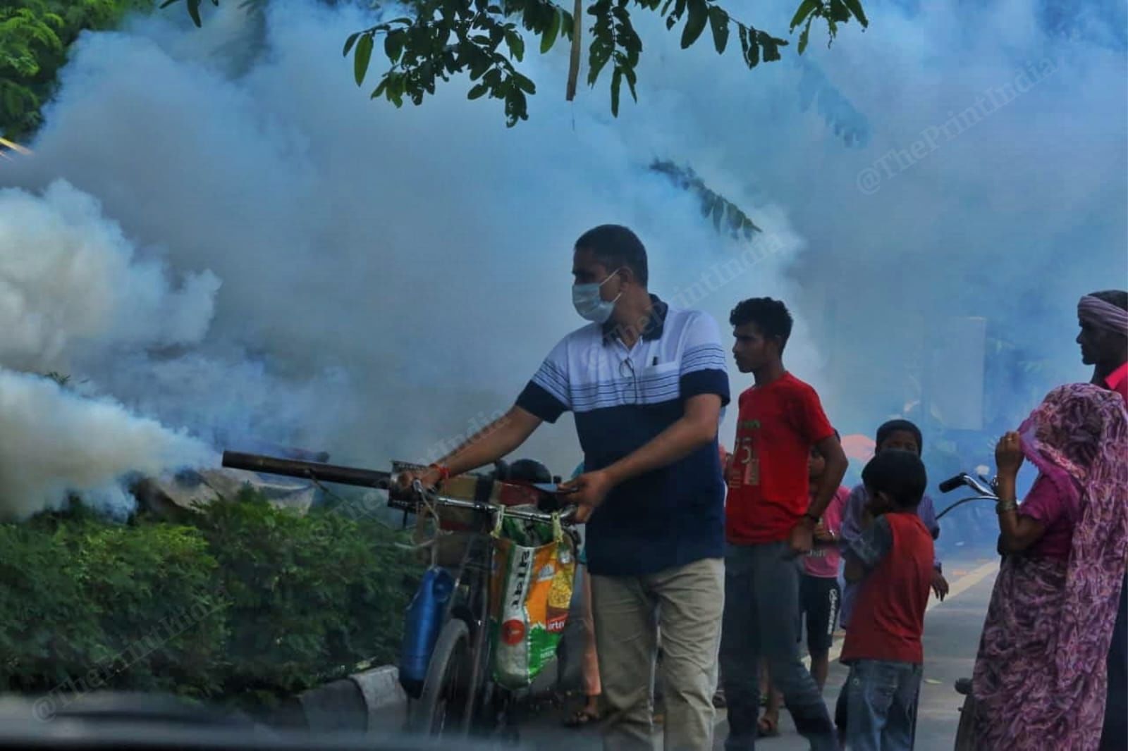 MCD worker carrying out fumigation drives near temporary shelters to protect people from mosquito-borne diseases | Praveen Jain | ThePrint.