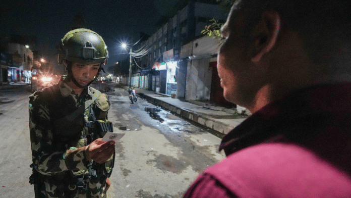 A soldier checks documents of a commuter in the aftermath of anti-government protests in Birgunj, Nepal | PTI