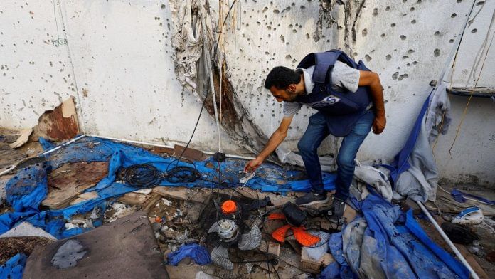 A member of the media inspects the damage at the site of an Israeli strike on a tent near Shifa Hospital, where Al Jazeera journalists Anas Al Sharif, Mohammed Qreiqeh, Ibrahim Zaher and Mohammed Noufal were killed, in Gaza City | 11 August, 2025 | Reuters