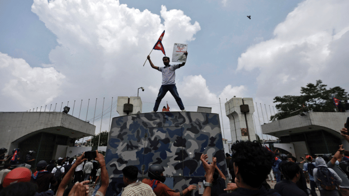 A demonstrator waves a flag as he stands atop a vehicle near the entrance of the Parliament during a protest against corruption and government’s decision to block several social media platforms, in Kathmandu, Nepal, 8 September 2025