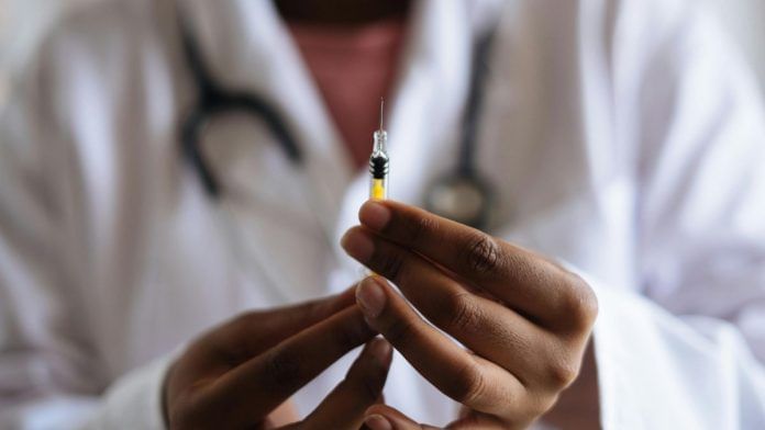 Man holding an injecting, which represents a vaccine.