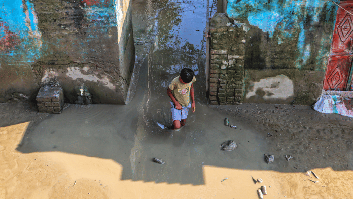 A youngster makes his way through murky water at a flood-hit area as the level of the Yamuna river continues to recede, in New Delhi, Tuesday, Sept. 9, 2025 | PTI