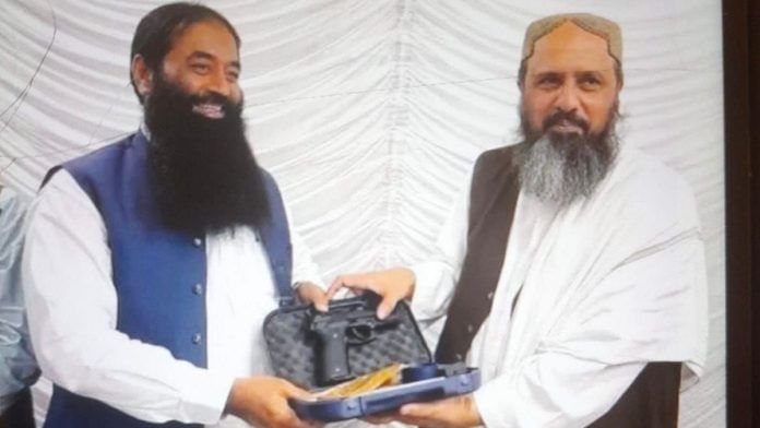 Photograph showing ISKP’s coordinator in Balochistan Mir Shafiq Mengal (R) handing over pistol to senior Lashkar commander Rana Md Ashfaq | By special arrangement