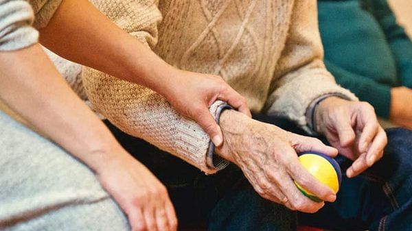 An old person holding a stress ball