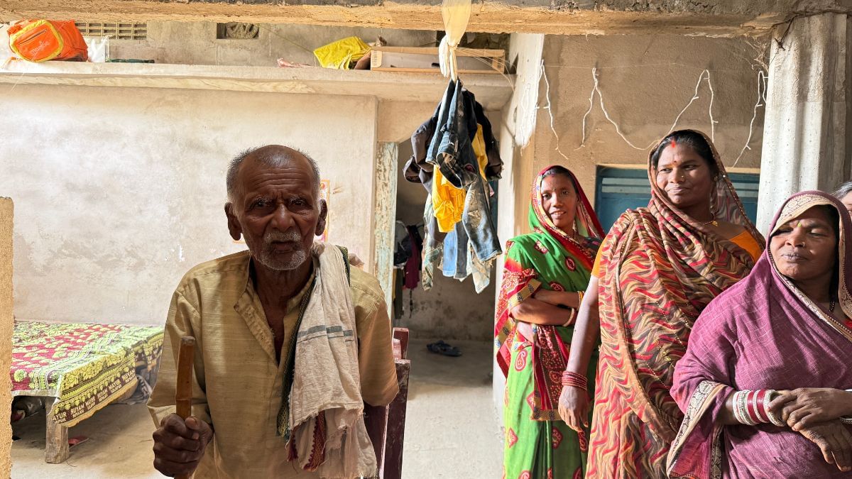 दिलीप के 80 वर्ष से ज्यादा उम्र के पिता, पक्के घर के अंदर खड़े हुए, वही घर जो उनके बेटे ने बनवाया. धनश्वर मुखिया ने पूरी ज़िंदगी दूसरों के खेतों में मेहनत की | फोटो: ज्योति यादव/दिप्रिंट