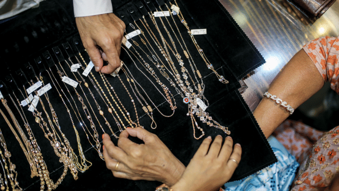 Customers look at necklaces inside a jewelry store during the festival of Dhanteras in Mumbai. Personal loans backed by gold surged 35% in the 12 months to June in India | Dhiraj Singh/Bloomberg