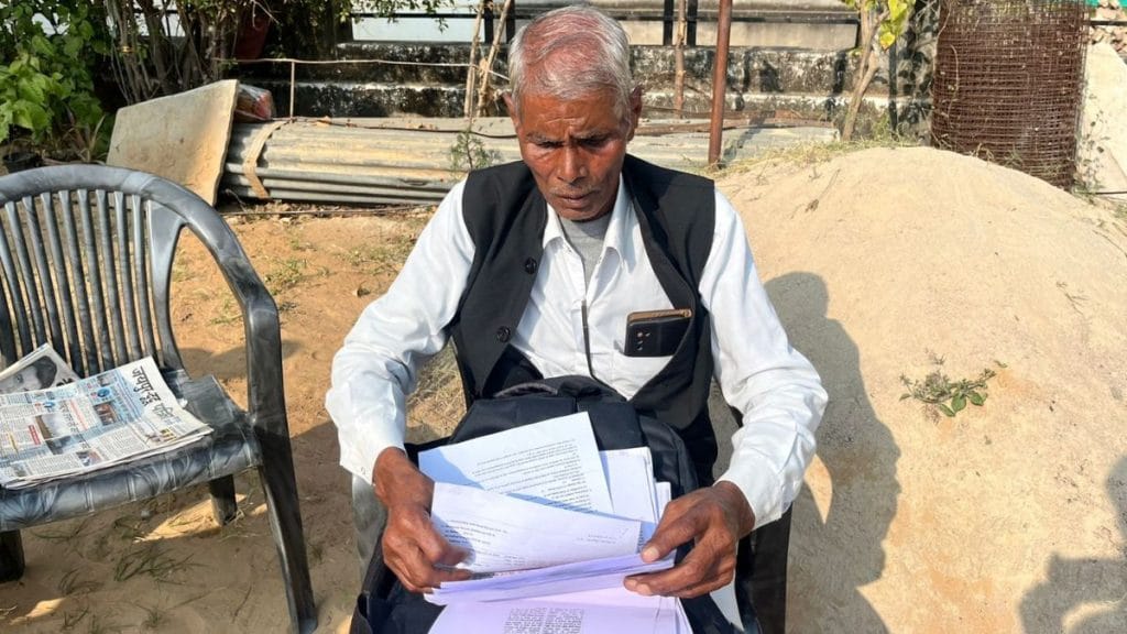 Mukesh Jangid’s father Nanakram, looking at a pile of documents related to his son’s death. Photo: Nootan Sharma | ThePrint