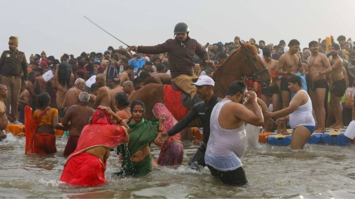 प्रयागराज महाकुंभ में 14 जनवरी 2025 को शाही स्नान के दौरान डुबकी लगाने आए श्रद्धालुओं की भीड़ को नियंत्रित करते घुड़सवार पुलिसकर्मी | फोटो: सूरज सिंह बिष्ट/दिप्रिंट