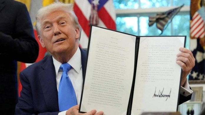 US President Donald Trump displays a signed executive order on the gold card visa in the Oval Office at the White House in September this year | Photo: Reuters
