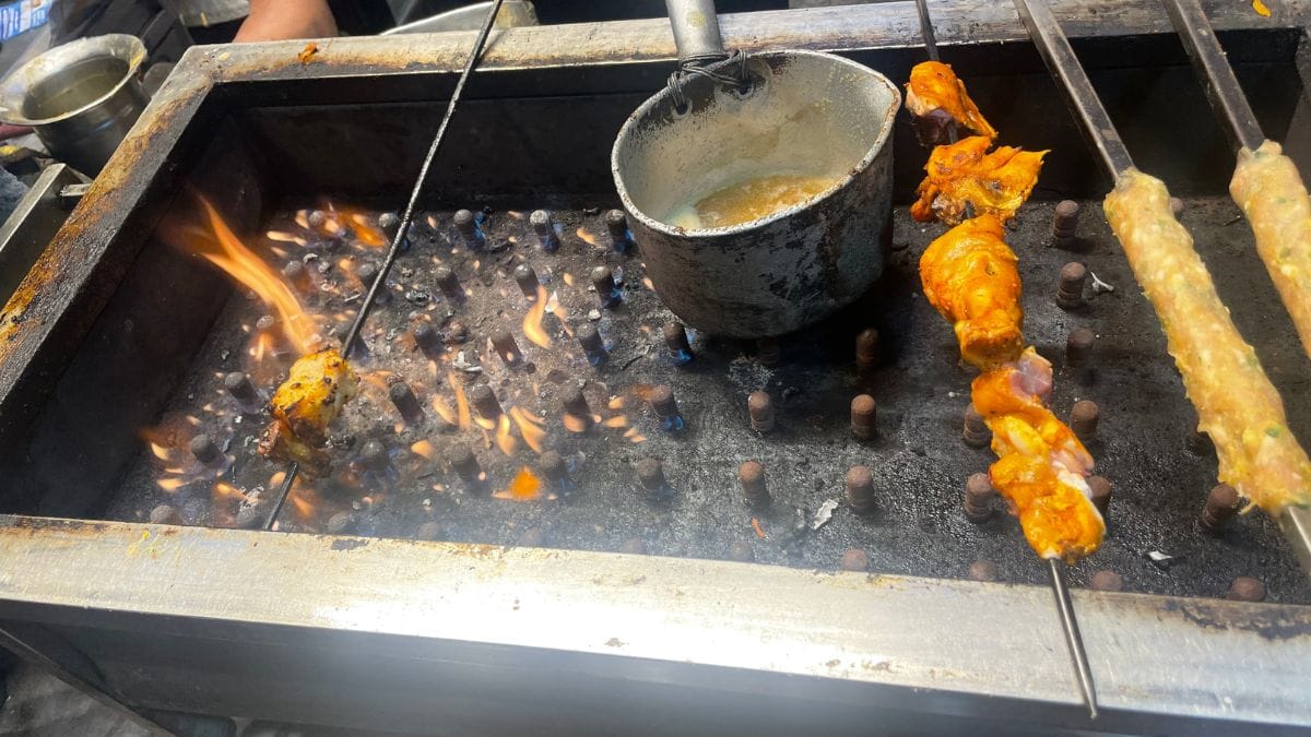 Chicken skewers being cooked on a gas stove at a shop in the old Delhi market, behind Jama Masjid | Triya Gulati, ThePrint