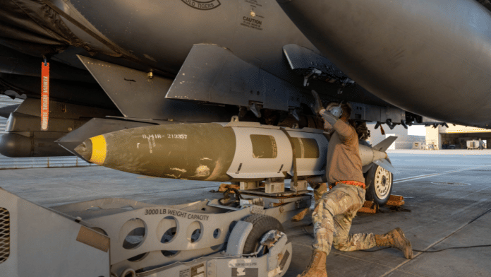 A U.S. Airman attaches a GBU-31 munitions system to an F-15E Strike Eagle in the U.S. Central Command area of responsibility, December 19, 2025, in support of Operation Hawkeye Strike as the U.S. military launched large-scale strikes against dozens of Islamic State targets in Syria in retaliation for an attack on U.S. personnel, U.S. officials said | Handout via Reuters